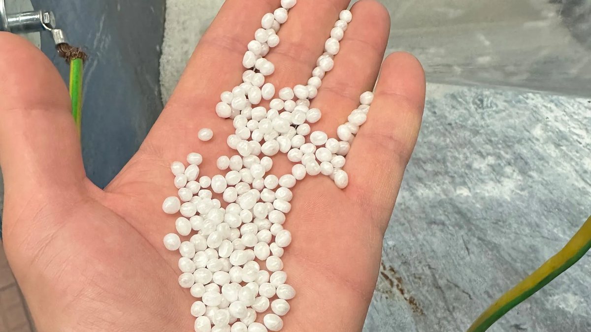 Witte Bioparels in de hand, het materiaal dat op de bodem van de kruipruimte komt